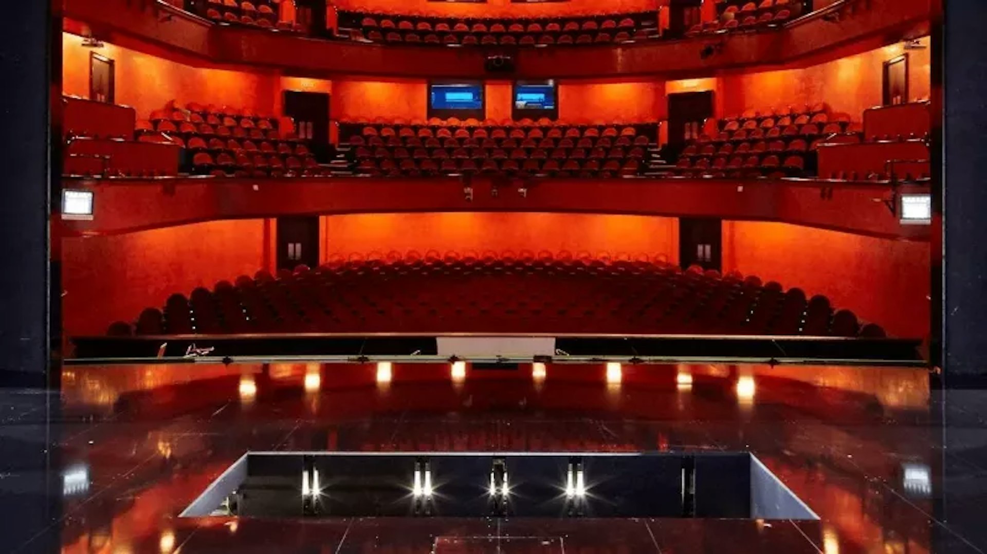 View from the stage of a theater with red seats