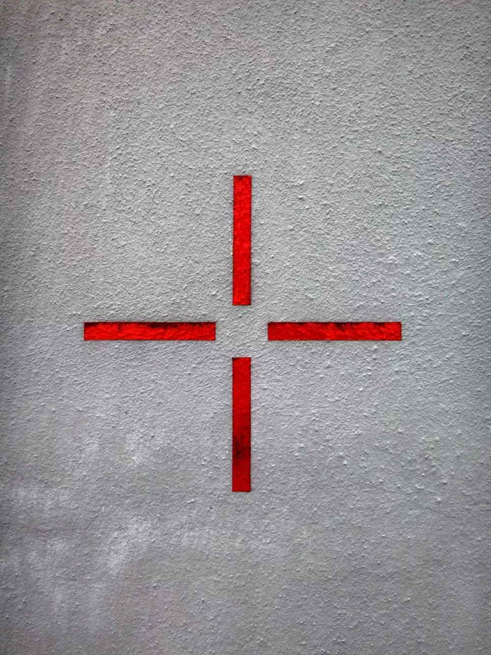 Red cross symbol on a grey wall